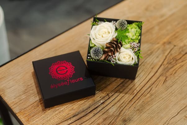 boite de fleurs, roses blanches, cone de pin, echinops